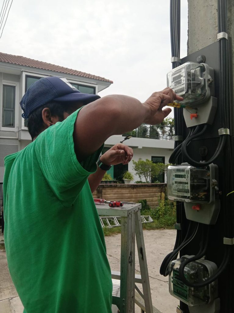 ช่างกำลังขันขั้วสายไฟที่มิเตอร์ไฟฟ้า