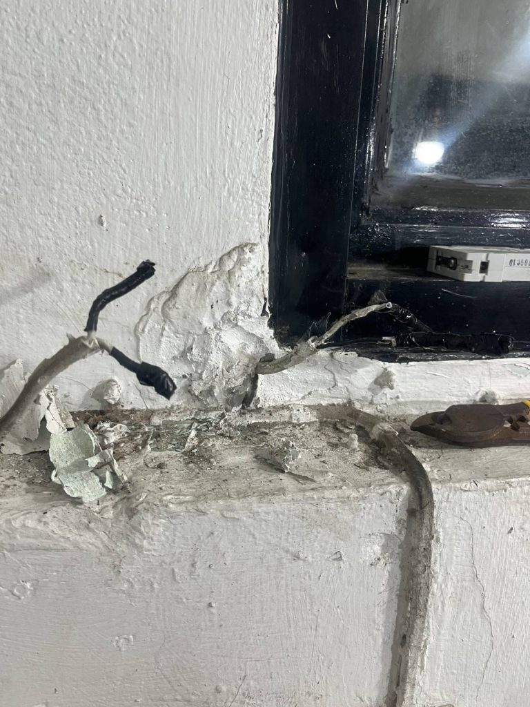 สายไฟชำรุดบริเวณขอบหน้าต่าง ฉนวนหลุดลอกบางส่วน