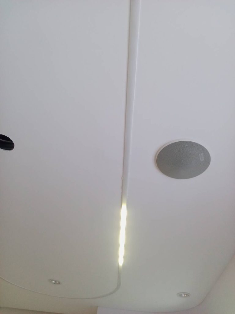 ไฟเส้น LED ติดตั้งบนเพดานพร้อมรางครอบสายไฟและลำโพงฝังเพดาน สำหรับเพิ่มแสงสว่างและความสวยงามภายในห้อง