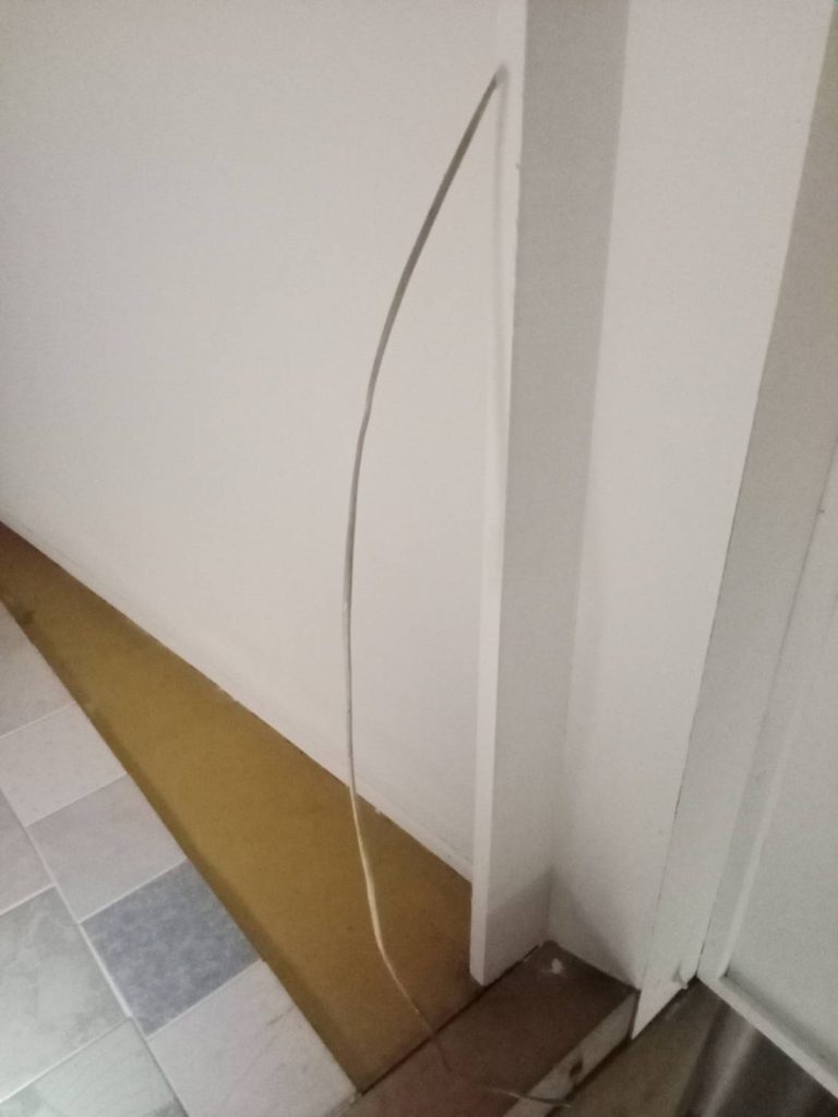 สายไฟโผล่ออกจากผนัง ยังไม่ได้เก็บเข้าระบบรางหรือท่อร้อยสาย
