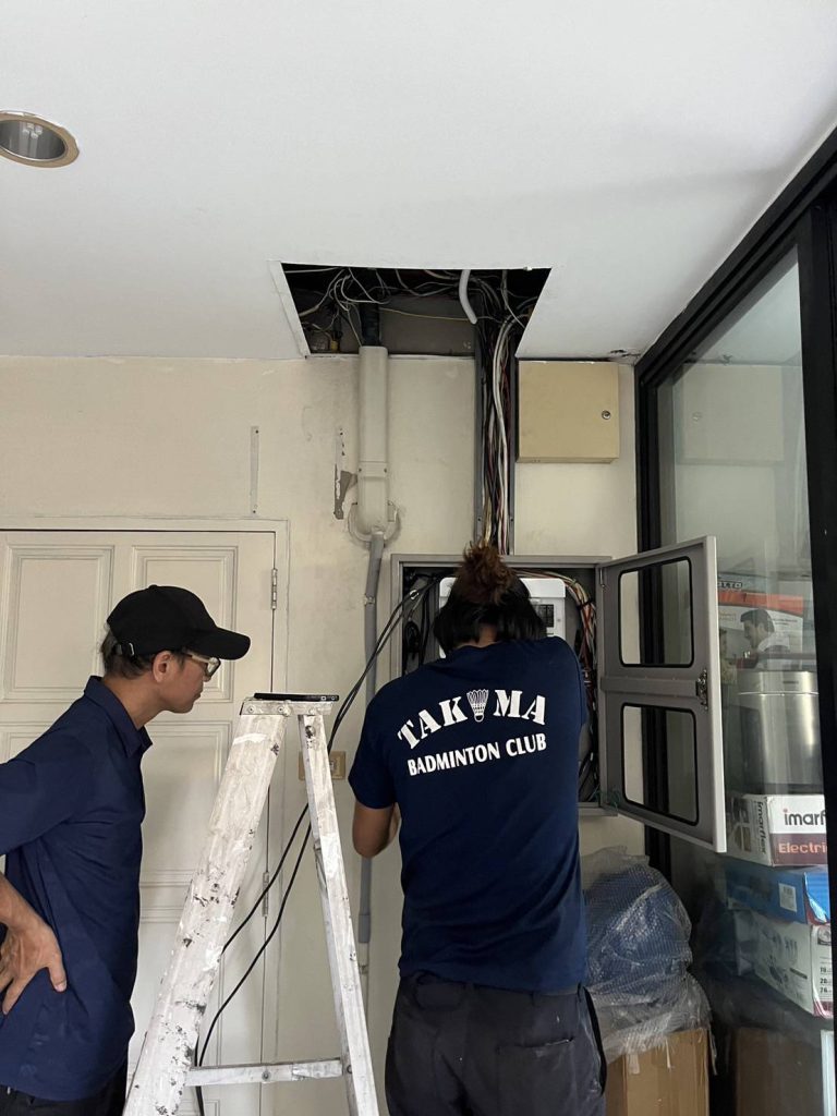 ช่างกำลังติดตั้งระบบไฟในตู้ควบคุม