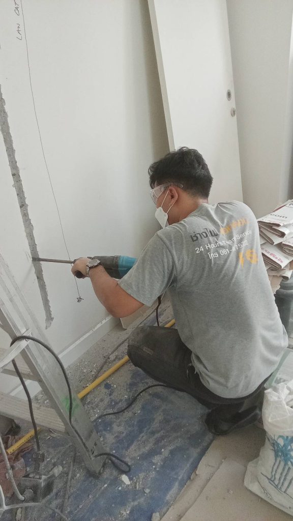ช่างไฟกำลังกรีดผนังเพื่อติดตั้งท่อร้อยสายไฟ