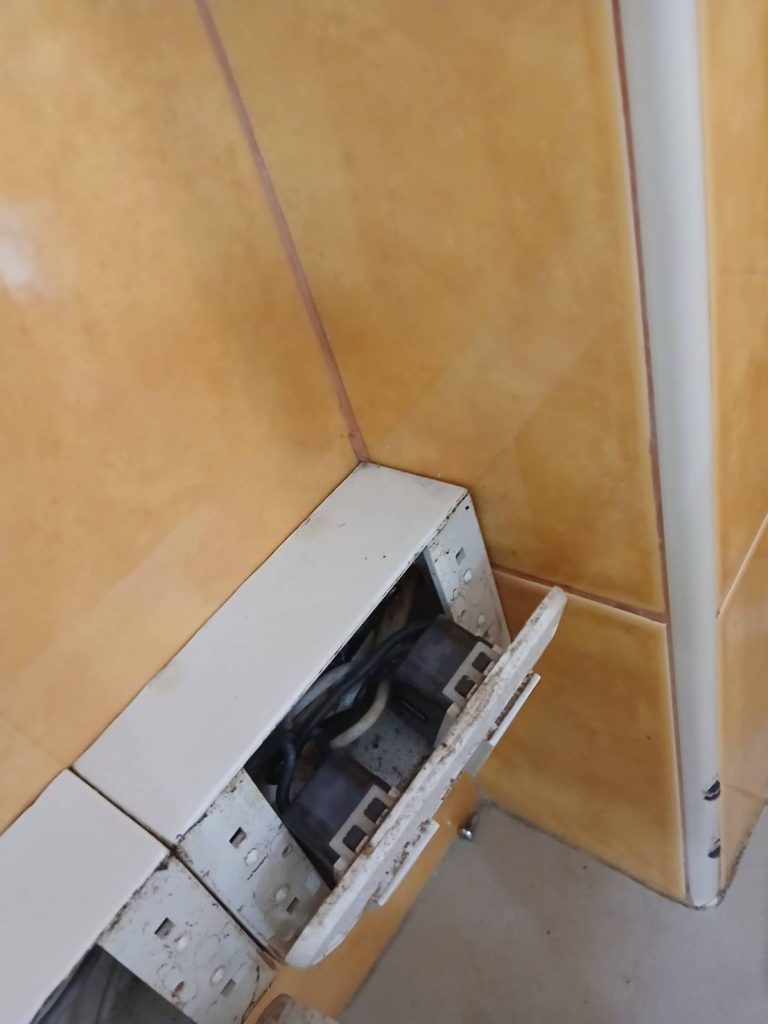 An open electrical outlet box with exposed wiring.