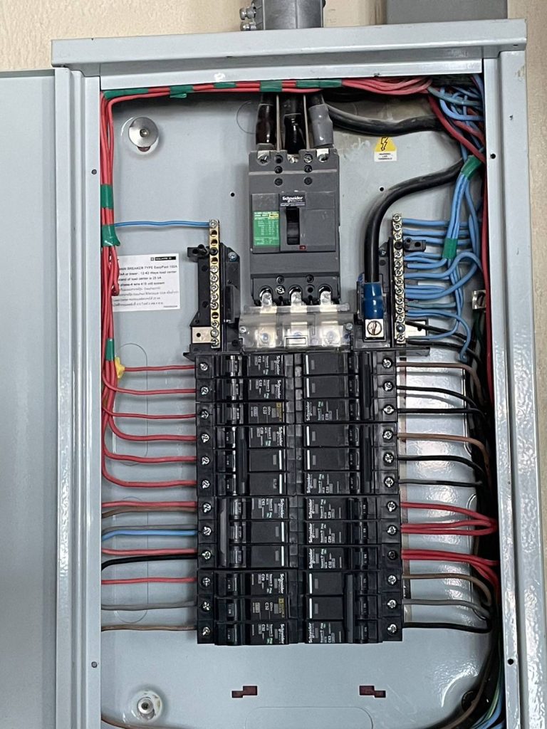 A neatly wired electrical distribution panel with Schneider circuit breakers.