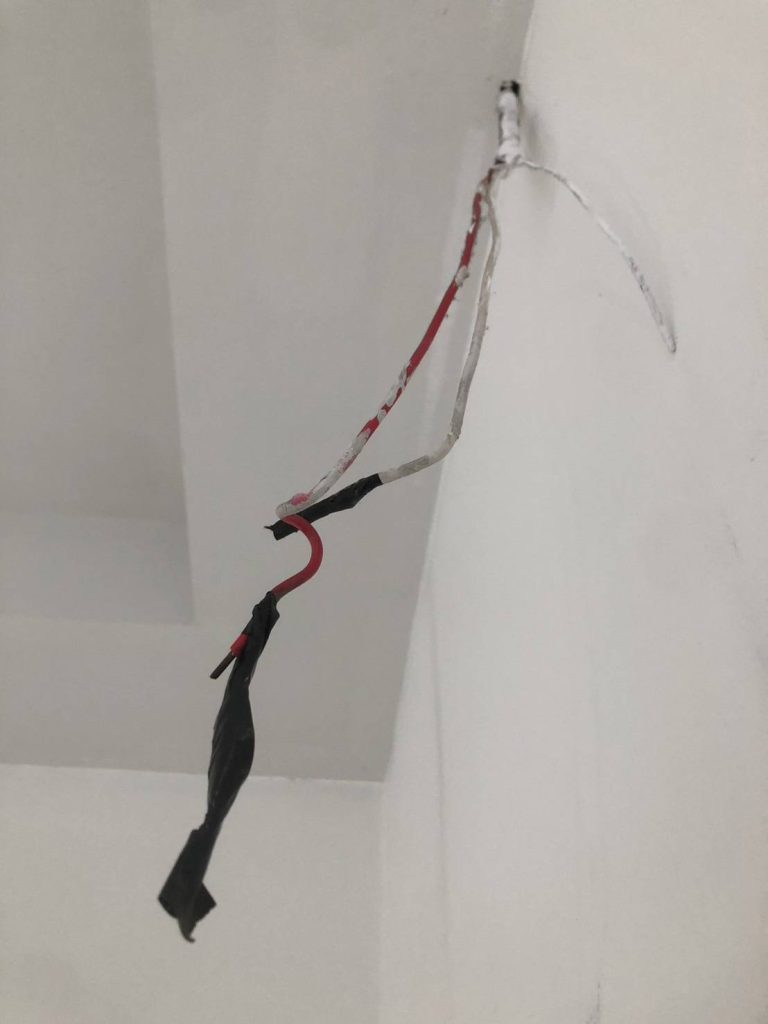 Exposed electrical wires hanging from the ceiling