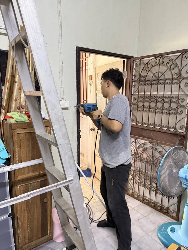 A technician is drilling near the doorway to install