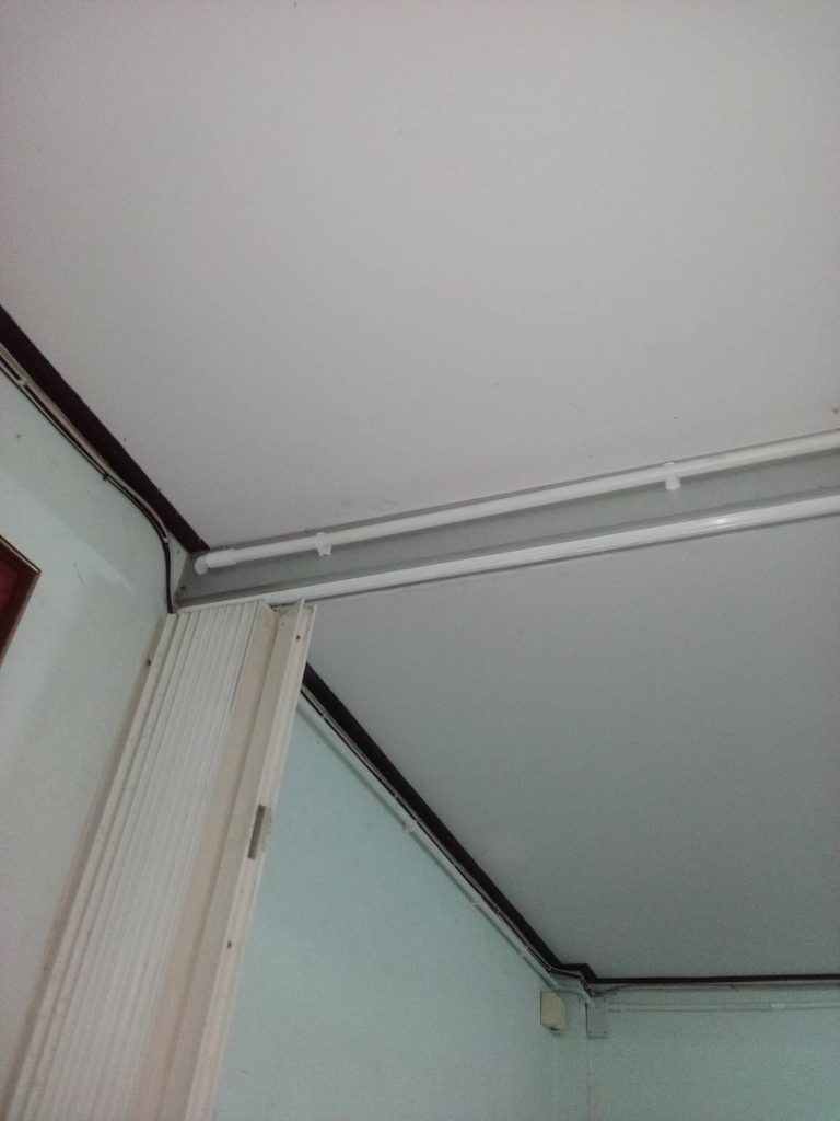 The electrical conduit protects and organizes the wires along the ceiling.